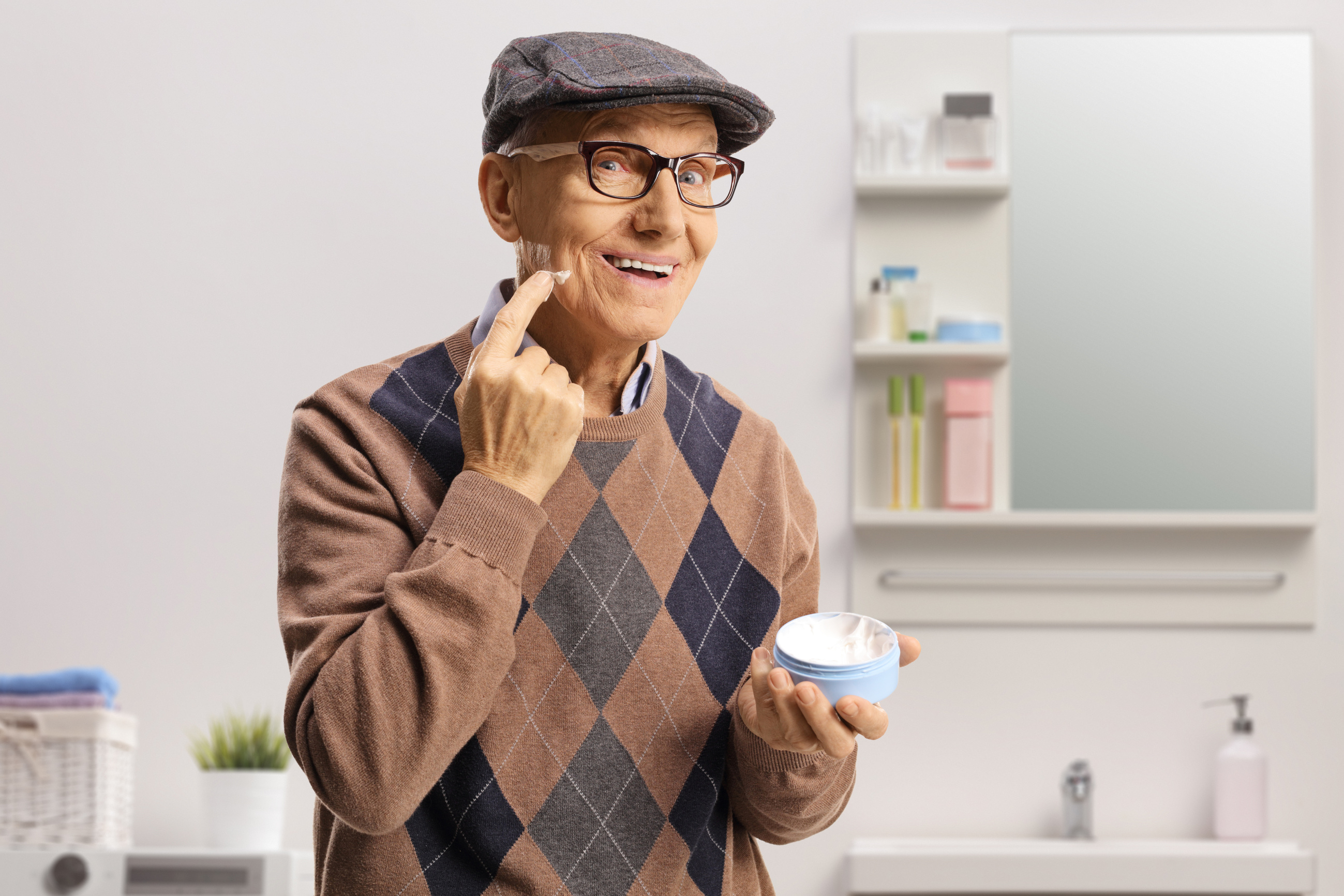 Elderly man putting on a face cream